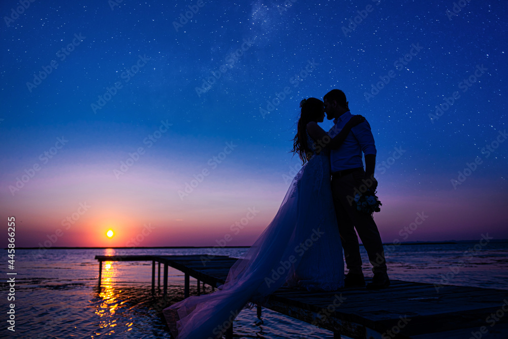 newlyweds on the ocean at sunset