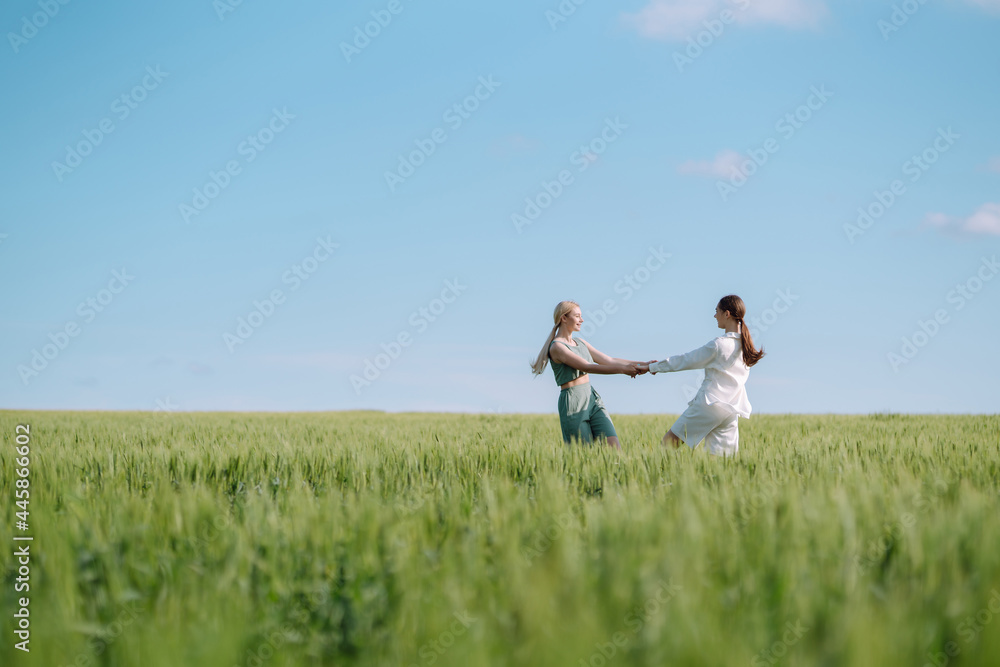 Portrait of two fair-haired girls in fashionable and stylish clothes, against the background of a field. Nature, vacation, relax and lifestyle. Fashion concept. Portrait of two fair-haired girls in fashionable and stylish clothes, against the background of a field. Nature, vacation, relax and lifestyle. Fashion concept.