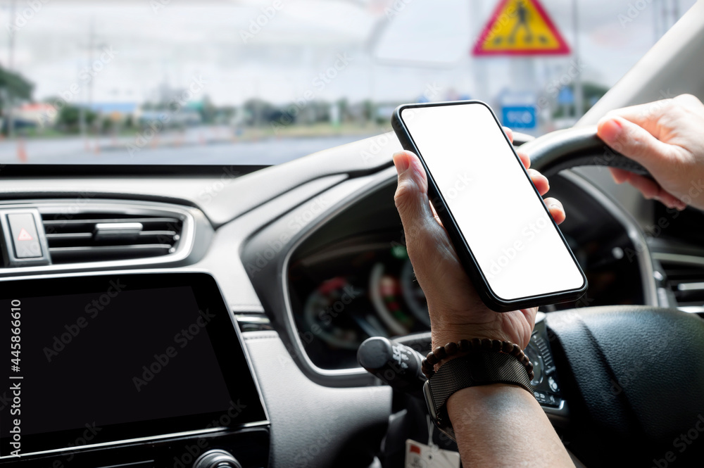 Cropped shot of man hand holding blank screen smartphone while driving.