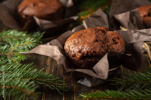 Delicious chocolate muffins on dark wooden background among fir branches, Merry Christmas and Happy New Year