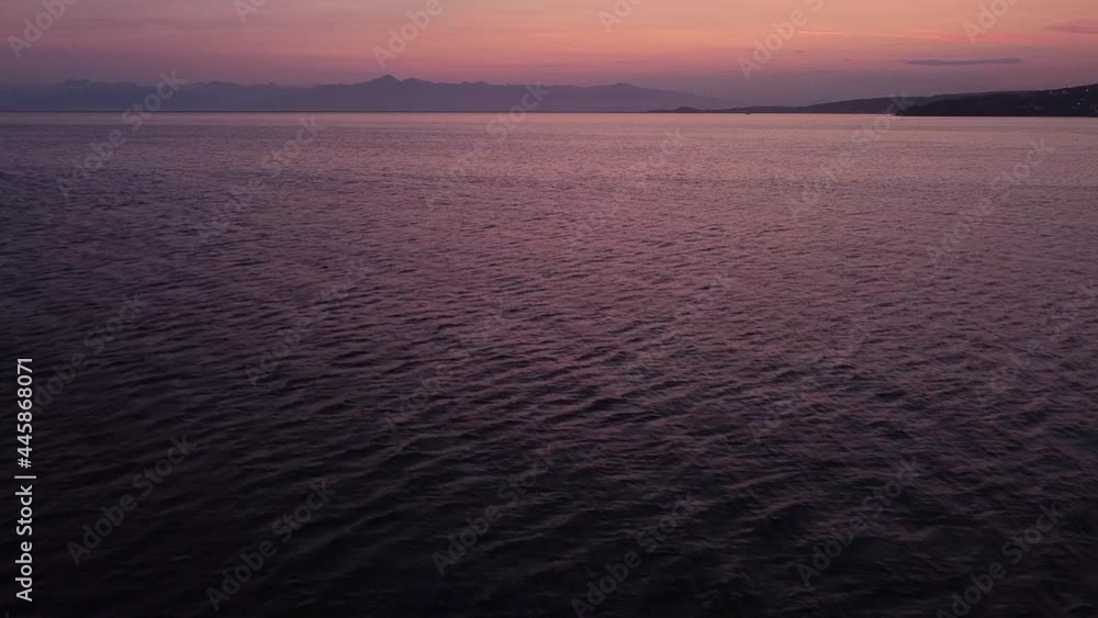 Flight over the bay of the Pacific Ocean towards the mountains at summer pink sunset. Kamchatka Peninsula. Flight over the bay of the Pacific Ocean towards the mountains at summer pink sunset. Kamchatka Peninsula.