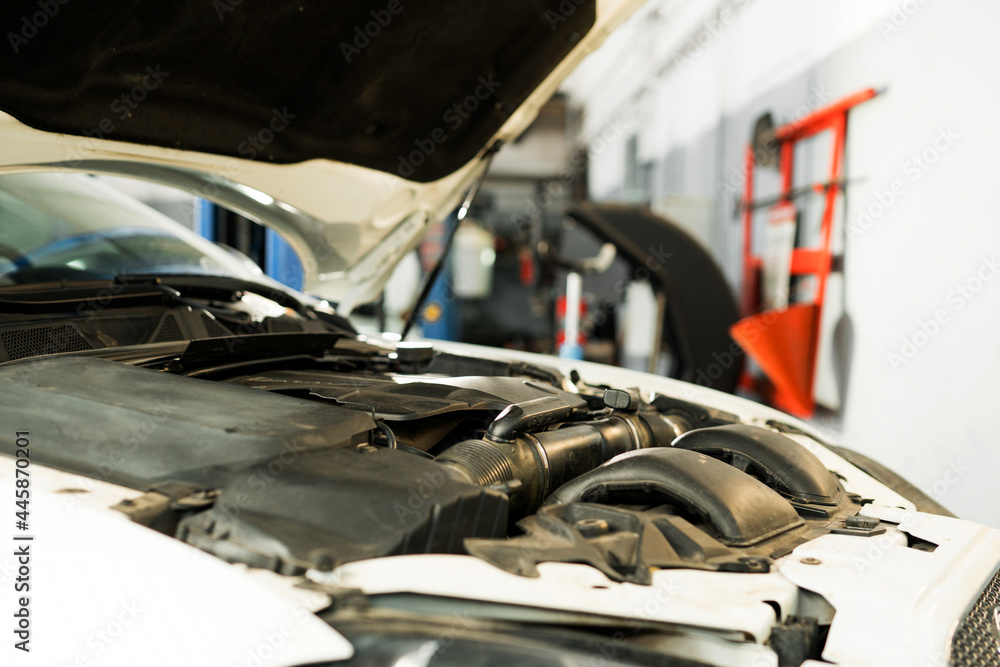 Close up photo. Open hood of the car with engine, battery and liquid containers. Car repairs Close up photo. Open hood of the car with engine, battery and liquid containers. Car repairs