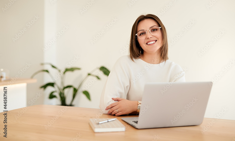 Smiling businesswoman with laptop working at table Smiling businesswoman with laptop working at table