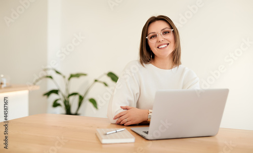 Smiling businesswoman with laptop working at table