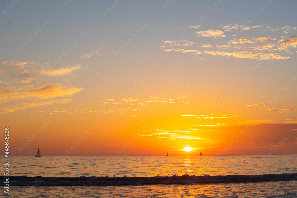 Sunset in the sea with beautiful clouds. Sunrise ocean seascape.