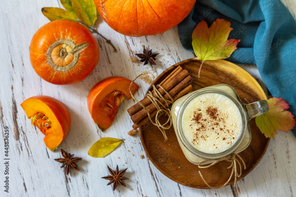 Autumn drink. Pumpkin spiced latte or coffee in glass on a rustic wooden table. Top view flat lay background. Autumn drink. Pumpkin spiced latte or coffee in glass on a rustic wooden table. Top view flat lay background.