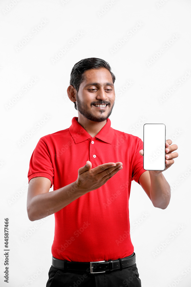 Portrait of a excited happy young delivery man in red t shirt and showing smartphone over white background. Portrait of a excited happy young delivery man in red t shirt and showing smartphone over white background.