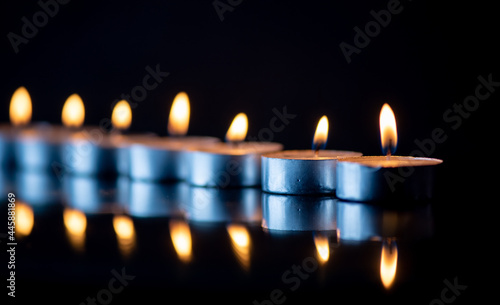 The bright flame of a dying candle on a dark background close-up.