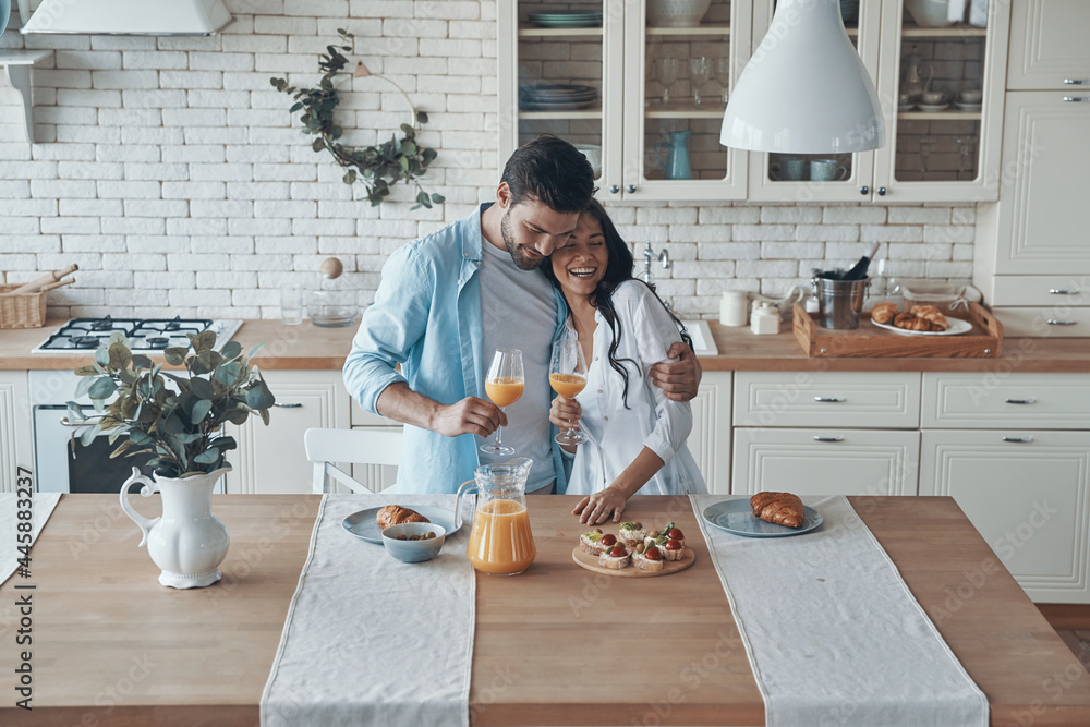 Beautiful young couple preparing breakfast together while spending time in the domestic kitchen Beautiful young couple preparing breakfast together while spending time in the domestic kitchen