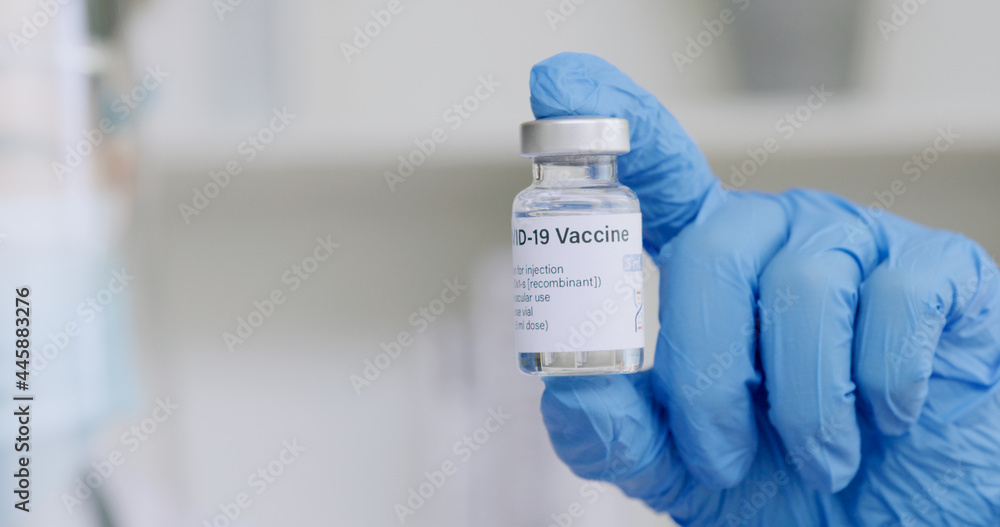 Hand of scientist or doctor holding COVID-19 vaccine bottle Hand of scientist or doctor holding COVID-19 vaccine bottle