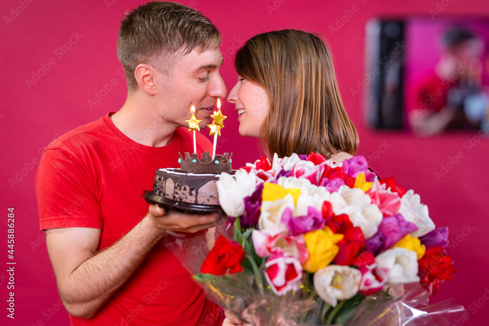 A young beautiful couple celebrate the consent of the bride with torte and a huge bouquet of flowers. A young beautiful couple celebrate the consent of the bride with torte and a huge bouquet of flowers.