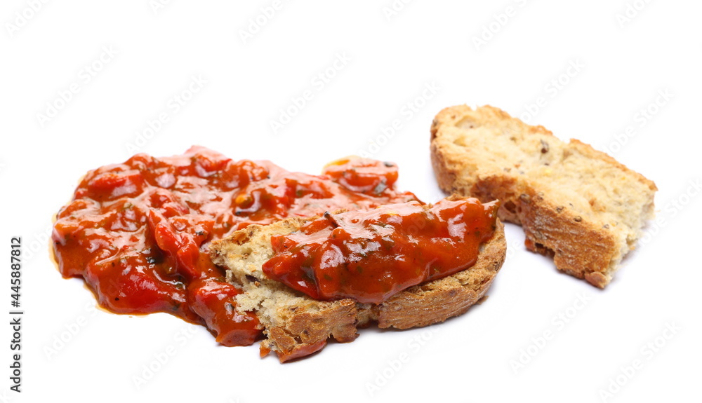 Pindjur relish made from red paprika, pepper and eggplant, vegetable sauce on slice of bread isolated on white background 