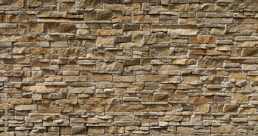 Wall cladding in brown natural stone made from bricks of irregular shape. Background and texture Wall cladding in brown natural stone made from bricks of irregular shape. Background and texture