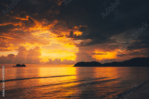 Sunrise, sunset over the beach and ocean waves on a tropical sea.