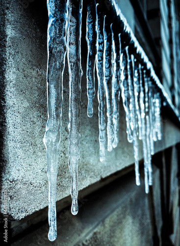 icicles at the wall in winter in the city  © Sina