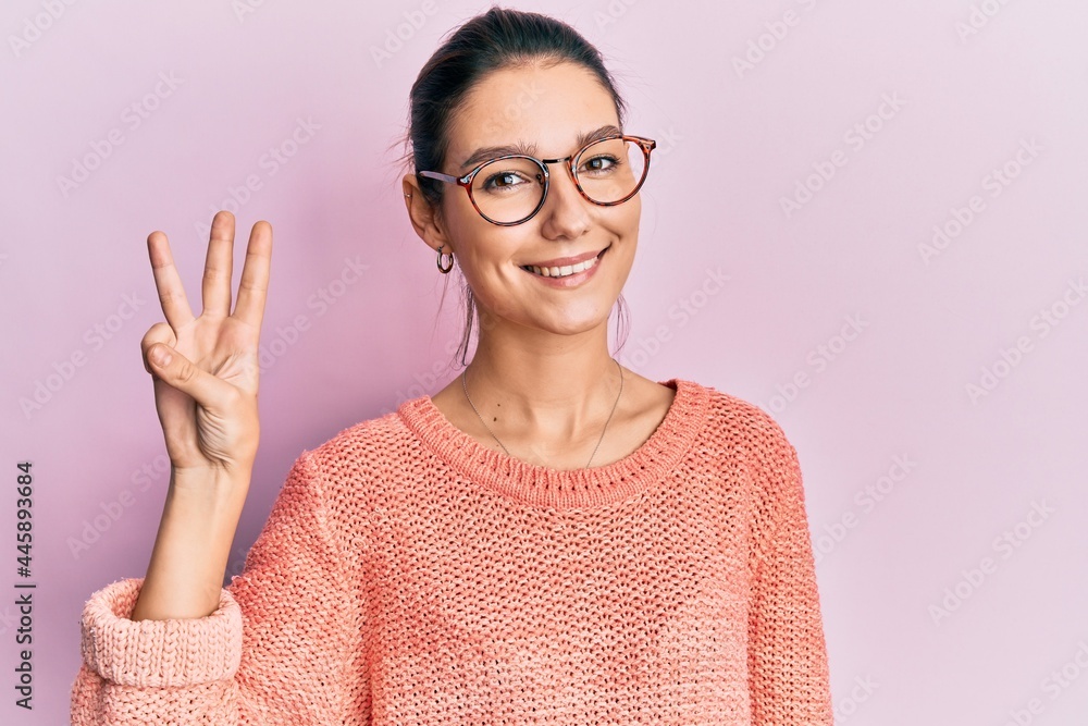 Young caucasian woman wearing casual clothes and glasses showing and pointing up with fingers number three while smiling confident and happy. Young caucasian woman wearing casual clothes and glasses showing and pointing up with fingers number three while smiling confident and happy.