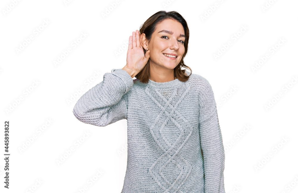 Young caucasian girl wearing casual clothes smiling with hand over ear listening an hearing to rumor or gossip. deafness concept. Young caucasian girl wearing casual clothes smiling with hand over ear listening an hearing to rumor or gossip. deafness concept.