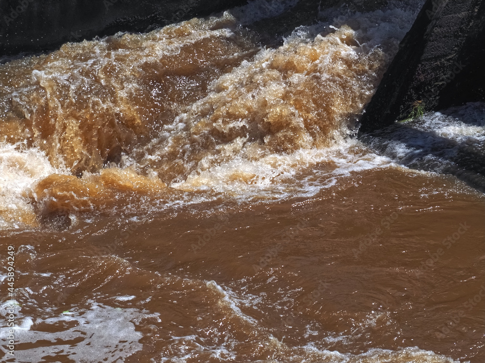 Fototapeta premium Brown muddy water of Erft river in a weir in Grevenbroich in Germany
