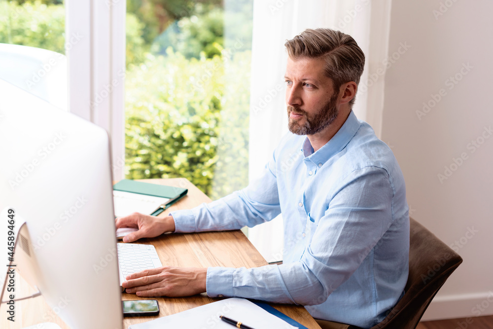 Businessman using computer while working from home Businessman using computer while working from home