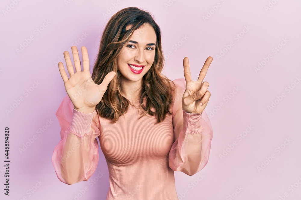 Young hispanic girl wearing casual clothes showing and pointing up with fingers number seven while smiling confident and happy. Young hispanic girl wearing casual clothes showing and pointing up with fingers number seven while smiling confident and happy.