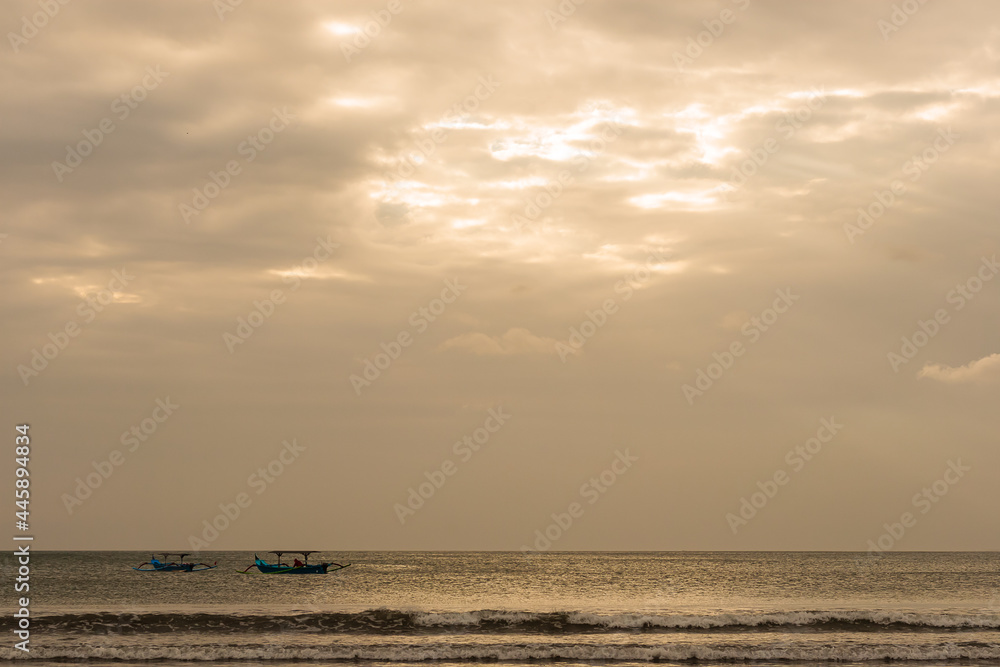 Two Indonesian traditional fishing boats on the sea at dusk Two Indonesian traditional fishing boats on the sea at dusk