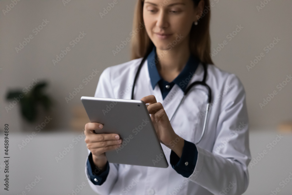 Focused doctor, physician using tablet computer, giving online virtual consultation, chatting to patient, making video call, reading electronic medical records. Telemedicine concept. Close up Focused doctor, physician using tablet computer, giving online virtual consultation, chatting to patient, making video call, reading electronic medical records. Telemedicine concept. Close up