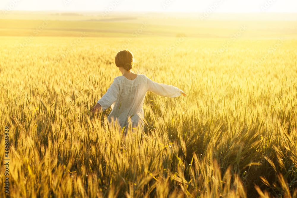 Happy young woman in dress in the middle of ripe wheat fieldHappy woman in dress in the middle of ripe wheat field