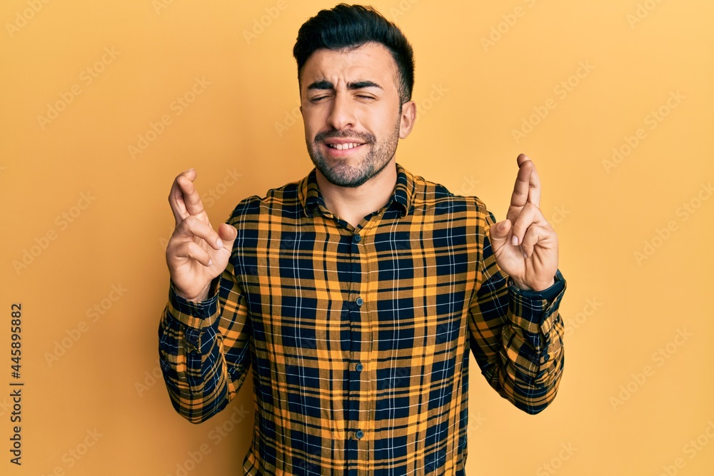 Young hispanic man wearing casual clothes gesturing finger crossed smiling with hope and eyes closed. luck and superstitious concept. Young hispanic man wearing casual clothes gesturing finger crossed smiling with hope and eyes closed. luck and superstitious concept.