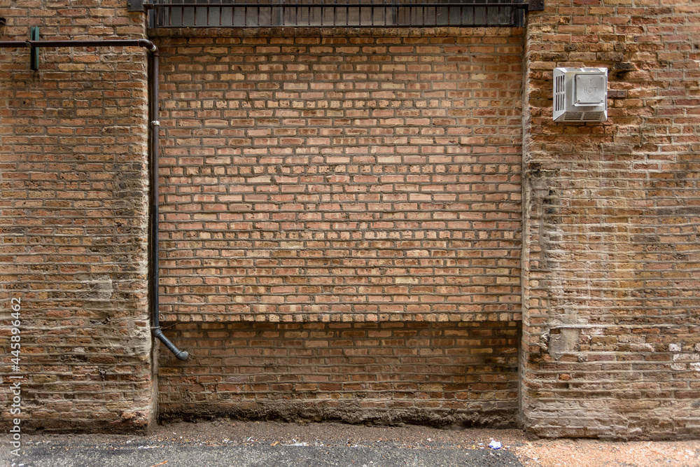 Vintage brown brick wall in alleyway of urban setting