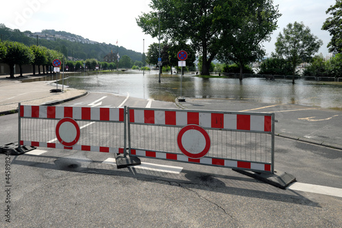 Absperrung und Verkehrsschild Verbot der Durchfahrt bei beginnendem Hochwasser auf Parkplatz am Rhein in Vallendar bei Koblenz - Stockfoto