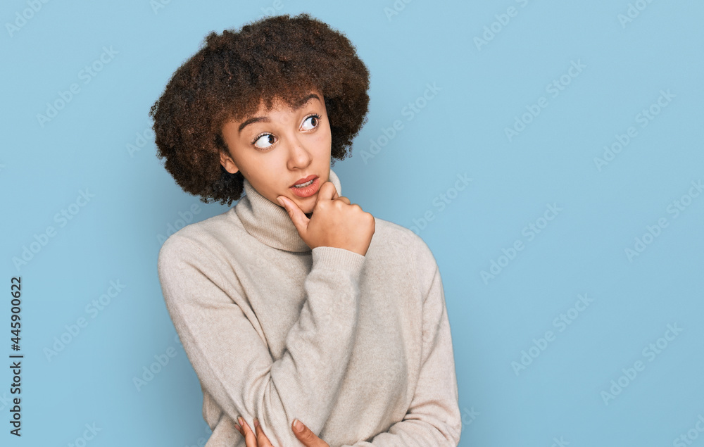 Young hispanic girl wearing wool winter sweater thinking worried about a question, concerned and nervous with hand on chin Young hispanic girl wearing wool winter sweater thinking worried about a question, concerned and nervous with hand on chin