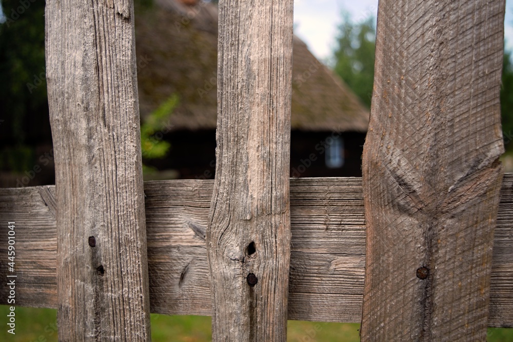 Rails of a rural wooden fence with a hut in the background. Rails of a rural wooden fence with a hut in the background.