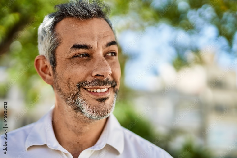Fototapeta premium Middle age grey-haired man smiling happy standing at the city.