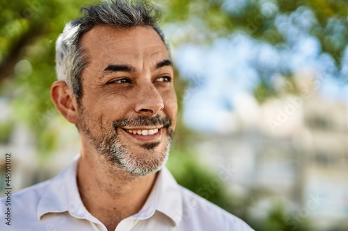 Middle age grey-haired man smiling happy standing at the city.