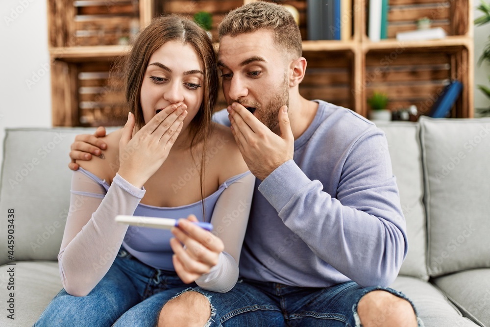 Young caucasian couple surprised looking pregnant test result at home. Young caucasian couple surprised looking pregnant test result at home.