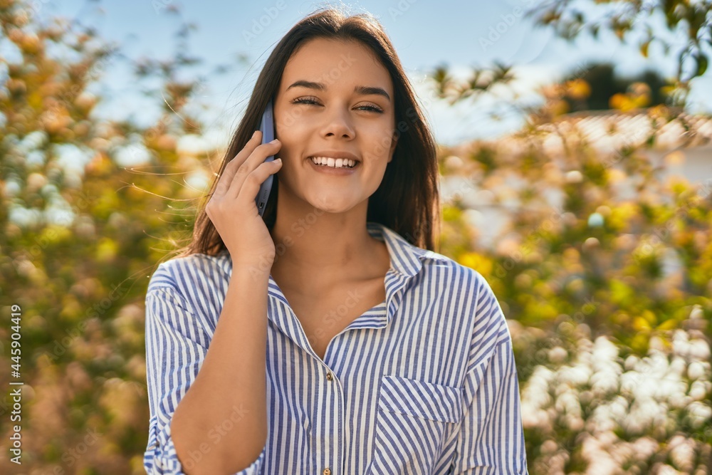Young hispanic girl smiling happy talking on the smartphone at the city. Young hispanic girl smiling happy talking on the smartphone at the city.