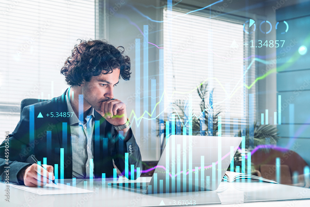 © ImageFlow - Handsome Hispanic financial trader analyzing stock graph chart and taking notes to predict the market rise, fundamental analysis, side view of working businessman. Internet trading