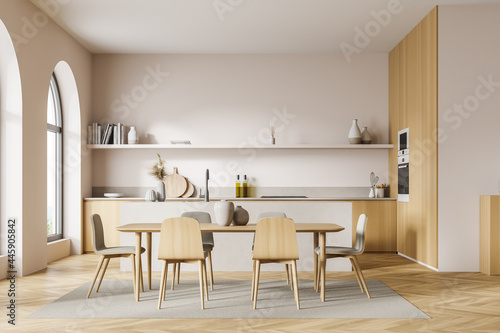 Front view of the light beige kitchen with arch window  table