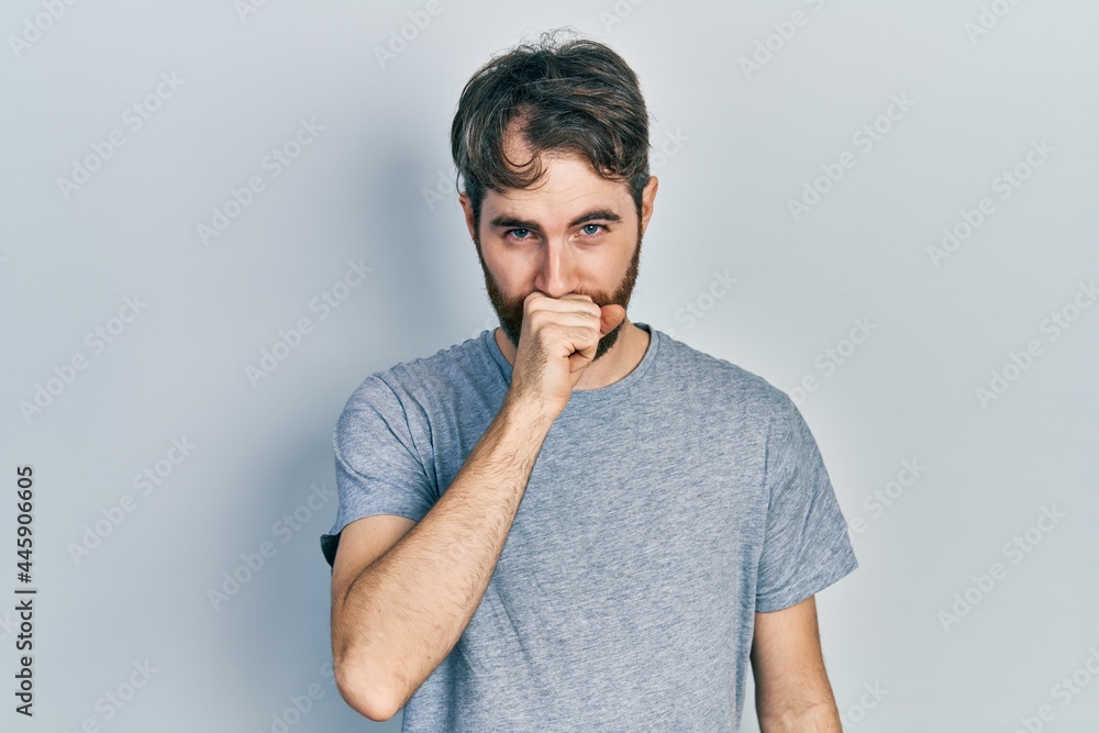 Caucasian man with beard wearing casual grey t shirt feeling unwell and coughing as symptom for cold or bronchitis. health care concept. Caucasian man with beard wearing casual grey t shirt feeling unwell and coughing as symptom for cold or bronchitis. health care concept.