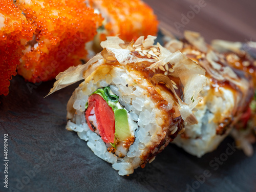 close-up of a sushi roll on a black plate. Traditional Japanese cuisine