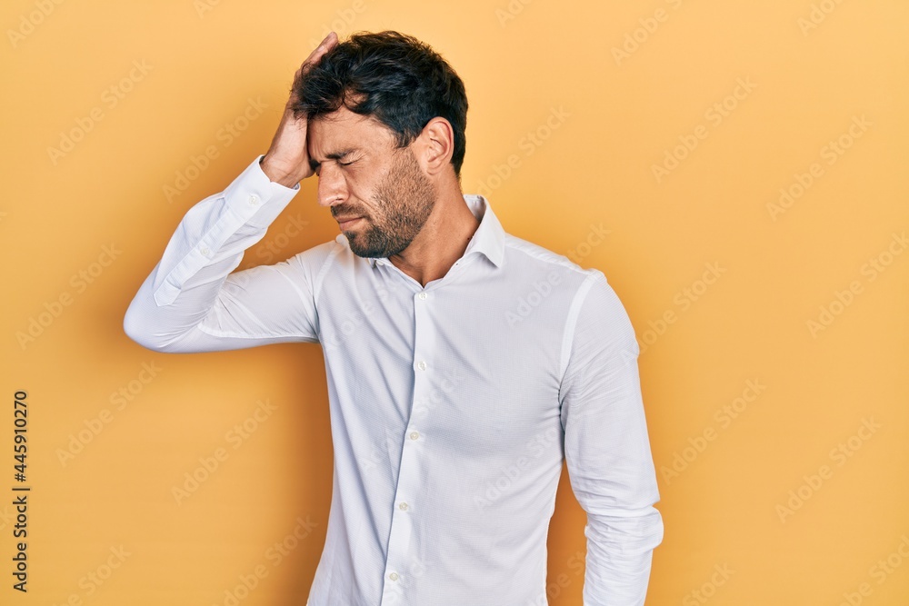 Handsome man with beard wearing casual white t shirt surprised with hand on head for mistake, remember error. forgot, bad memory concept. Handsome man with beard wearing casual white t shirt surprised with hand on head for mistake, remember error. forgot, bad memory concept.