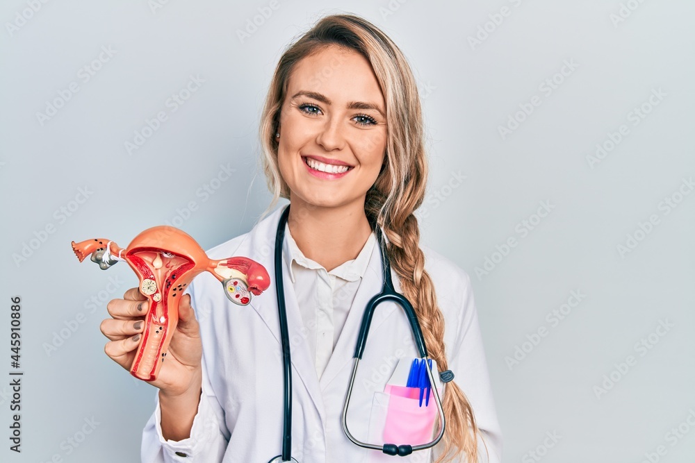 © Krakenimages.com - Beautiful young blonde woman holding anatomical model of female genital organ looking positive and happy standing and smiling with a confident smile showing teeth © Krakenimages.com - Beautiful young blonde woman holding anatomical model of female genital organ looking positive and happy standing and smiling with a confident smile showing teeth