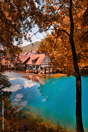 Blautopf in Blaubeuren im Herbst mit Spiegelung im blauen Wasser