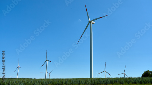 Wind turbine in the field against the blue sky © Juri