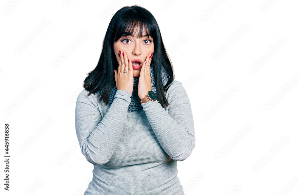 Young hispanic plus size woman wearing winter scarf afraid and shocked, surprise and amazed expression with hands on face Young hispanic plus size woman wearing winter scarf afraid and shocked, surprise and amazed expression with hands on face