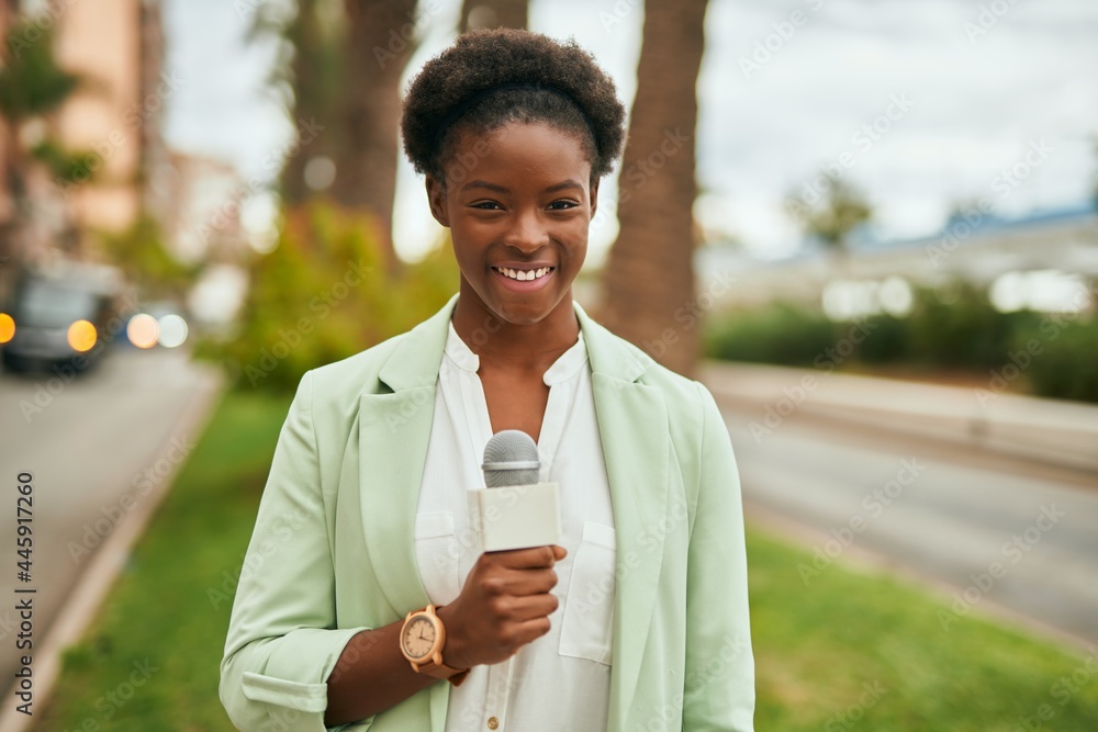 Young african american reporter woman using microphone at the city Young african american reporter woman using microphone at the city