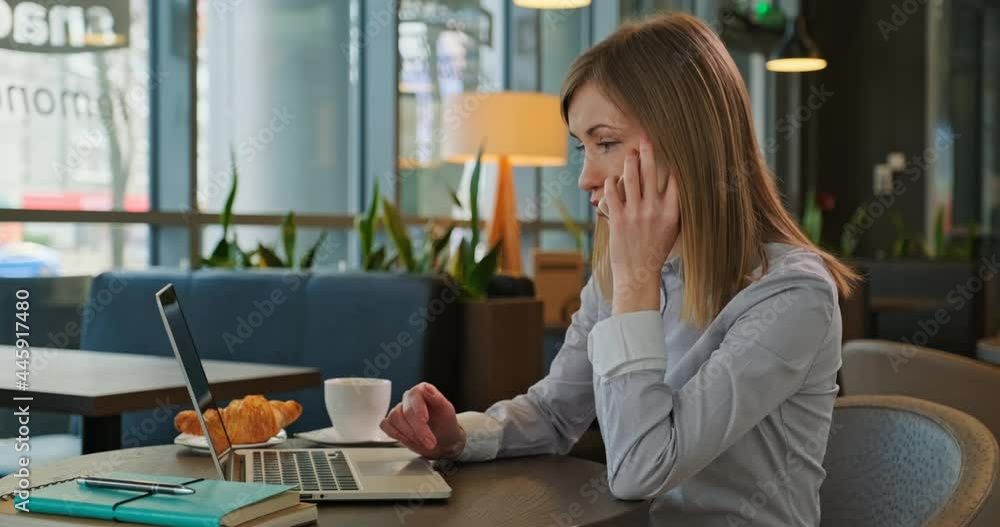 Businesswoman talking on the phone, working with laptop in the restaurant. Dolly shot Businesswoman talking on the phone, working with laptop in the restaurant. Dolly shot