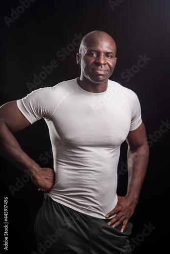 Portrait of a black man standing looking at camera with hands on waist