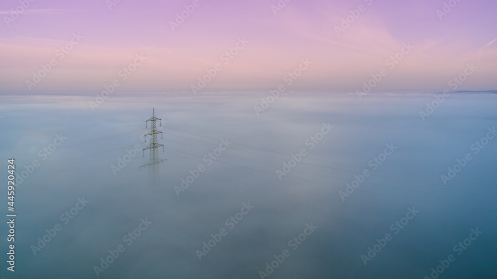 1 Power pole in the fog. Humid weather with colorful sky. Aerial view.