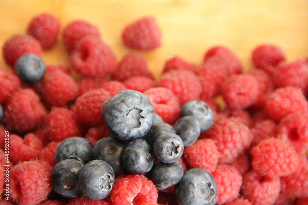 blueberries and raspberries on a wooden background blueberries and raspberries on a wooden background